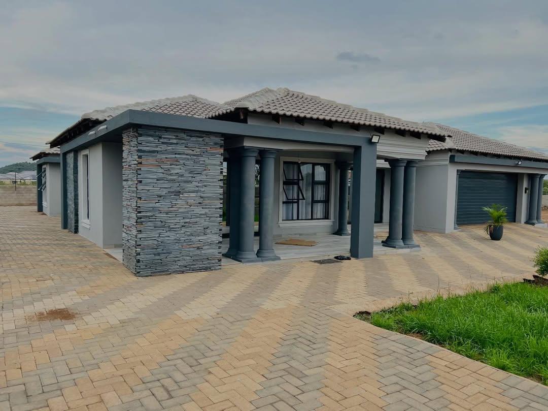 Completed home with stone-clad pillars and paved driveway